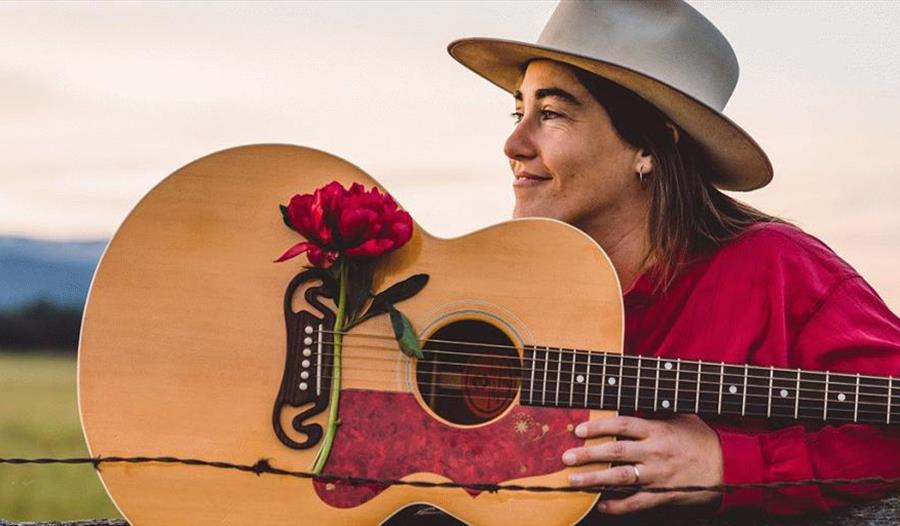 Margo Cilker med gitar dekorert med stor rød blomst