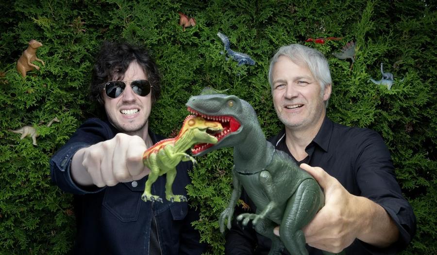 To menn som holder leketøysdinosaurer