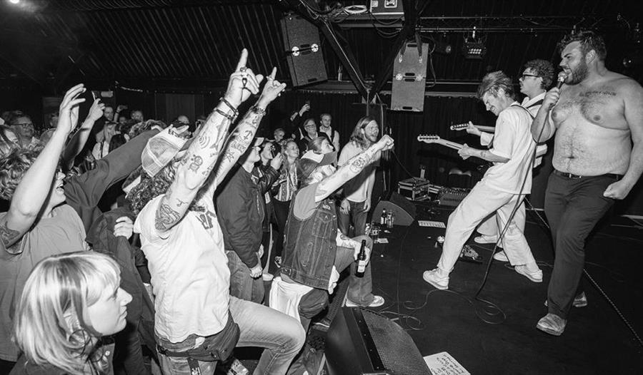 Publikum ønsker Tears of the Fatman-bandet velkommen til konserten.