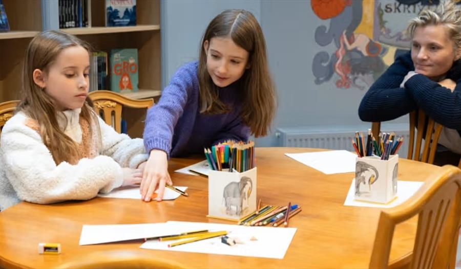 Barn sitter rund bordet og tegner