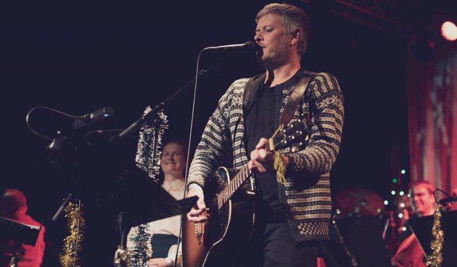 Sven Kulepenn med gitar på scenen