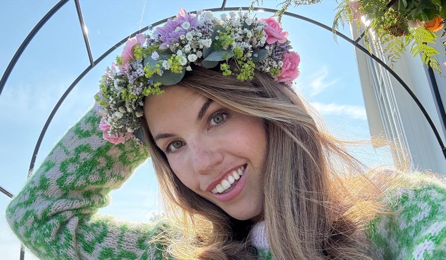 Hilde Selvikvåg med en krans av friske blomster på hodet