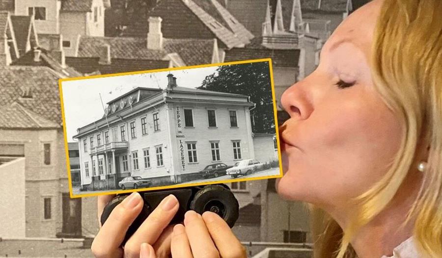 Tove Galta kysser bildet med gammel bygning