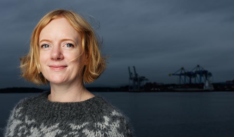 Erika Fatland med sjøen og havnekraner som bakgrunn