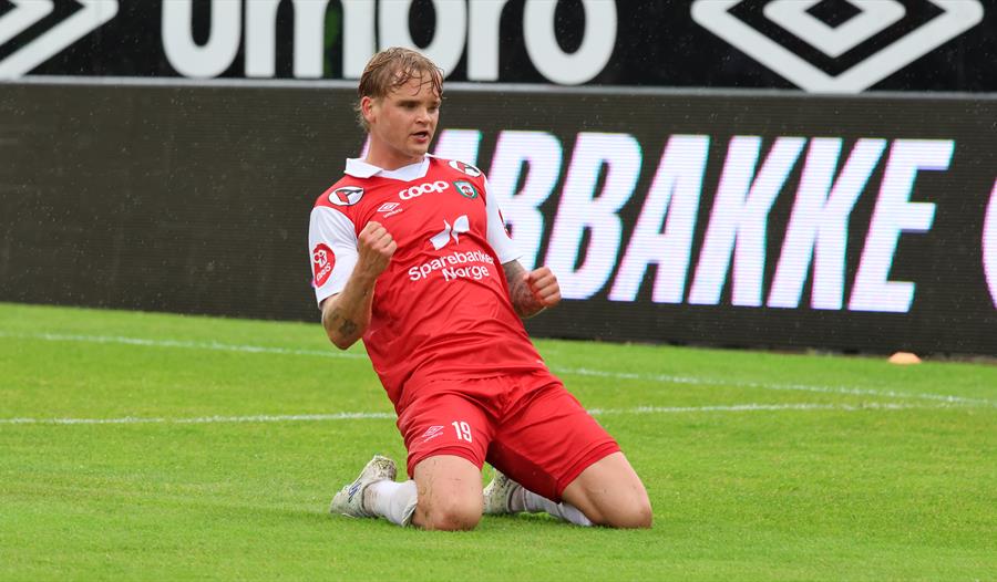 Fotballspiller står på kne på fotballbane