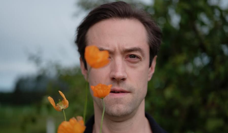 Matias Kuoppala med oransje blomster
