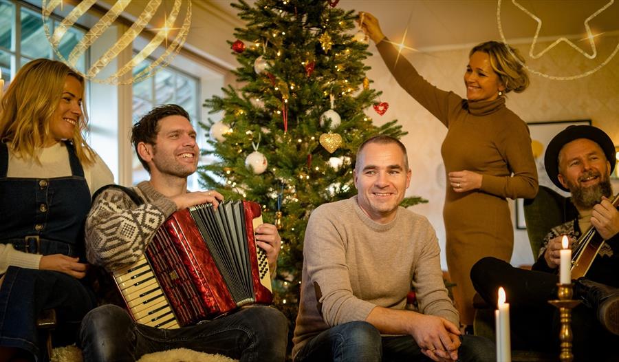 Øklands pop-gruppe sitter ved siden av juletre