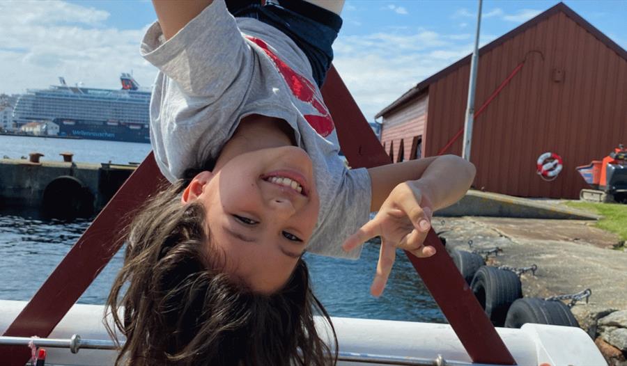 Jente som klatrer i et klatrestativ