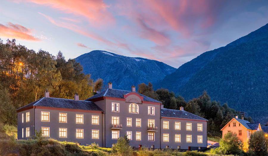 Magisk stemning ved Slottet Apartments i Hardanger, med vakker solnedgang over fjorden og fjella.