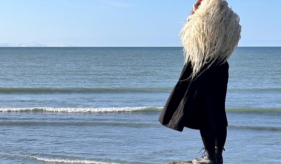 Påkledd i varafell, ser ut over havet