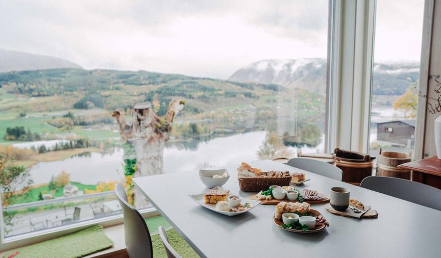 Eit bord fylt med lokal mat frå Hardanger med panoramautsikt over fjordlandskapet.