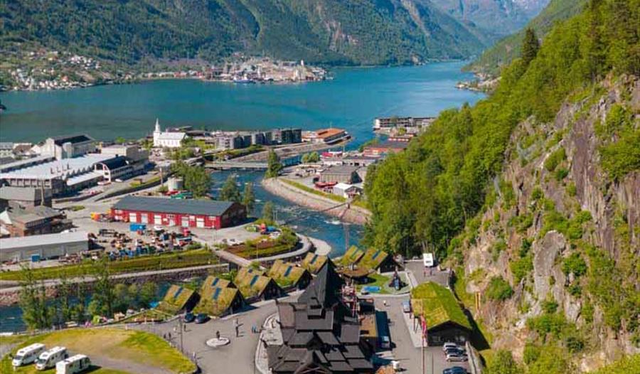 Oversikt over Odda med Valhall-anlegget nedst, Sørfjorden og snødekte fjell i bakgrunnen.