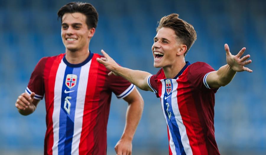 Bilde av to fotballspillere med norske flagg på T‑skjortene.