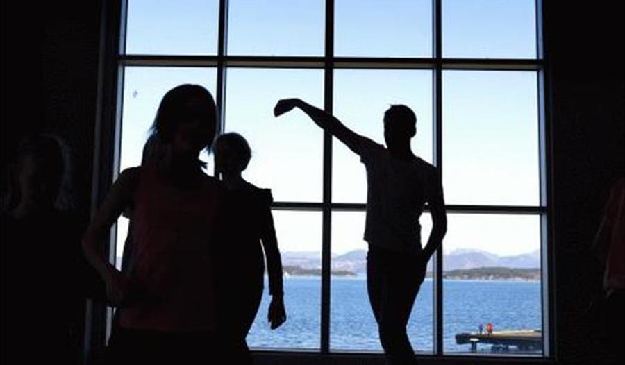 Folk som danser foran et vindu.