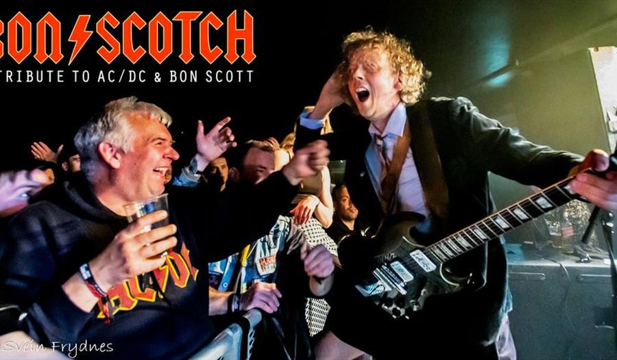 Plakat, som viser to menn som rocker en gitar, og annonserer for a tribute to AC/DC med Bon/Scotch