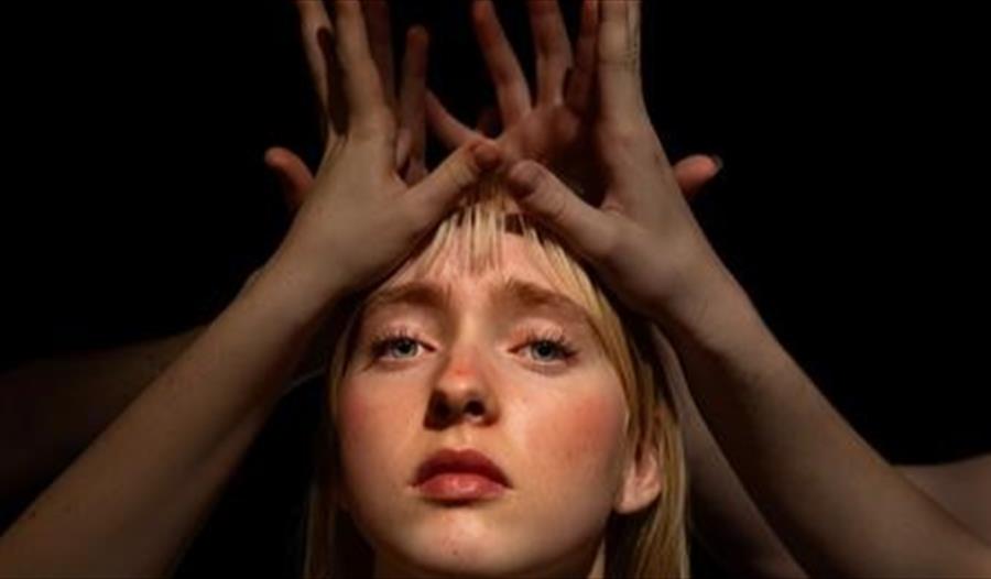 En jente med hendene hevet over hodet