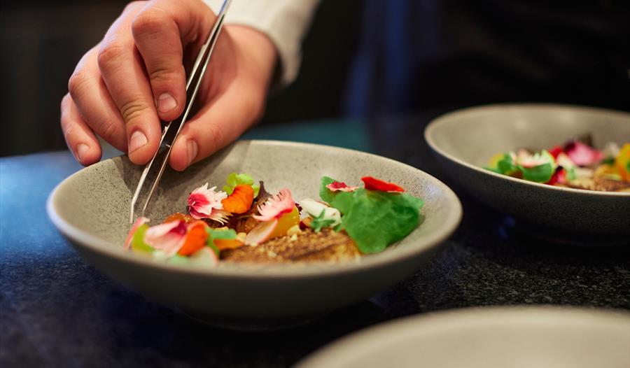 Kokken på Buer restaurant danderer en rett.