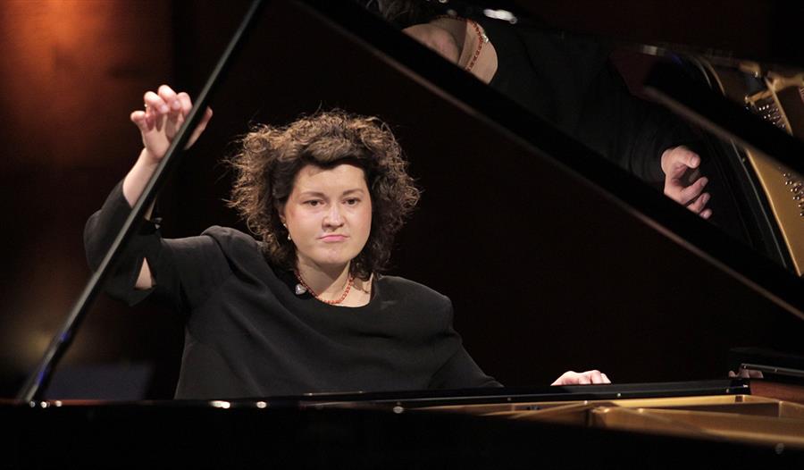 Ei kvinne som spiller piano på en stor scene