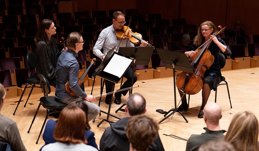 Fire artister som spiller klassisk musikk på instrumenter på en scene