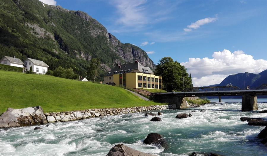 Trolltunga Hotel ligg idyllisk til ved elva med vakker utsikt over fjella i Hardanger.