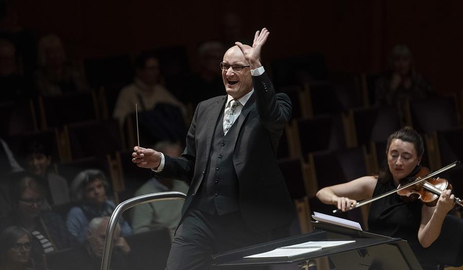 En dirigent og en violin-artist på en scene