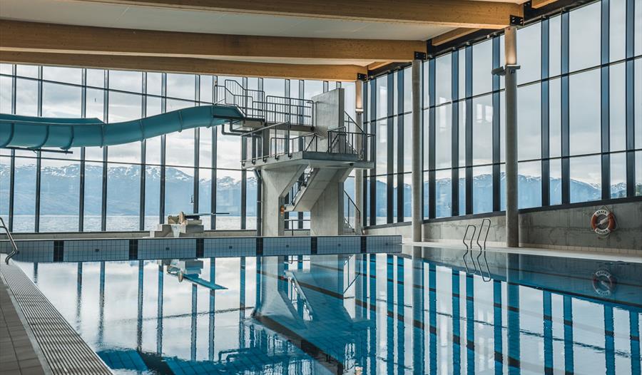Eit moderne basseng på Hardangerbadet med utsikt over fjord og fjell, perfekt for familieaktivitetar og avslapping.