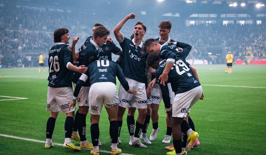 Ti Viking spillere feirer et mål foran fullsatte tribuner