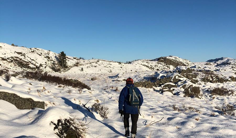 Mann som går i snøen