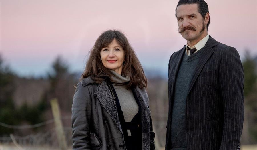 En mann og en kvinne, Rita Eriksen og Dag Vagle i naturen med rosa himmel i bakgrunnen.