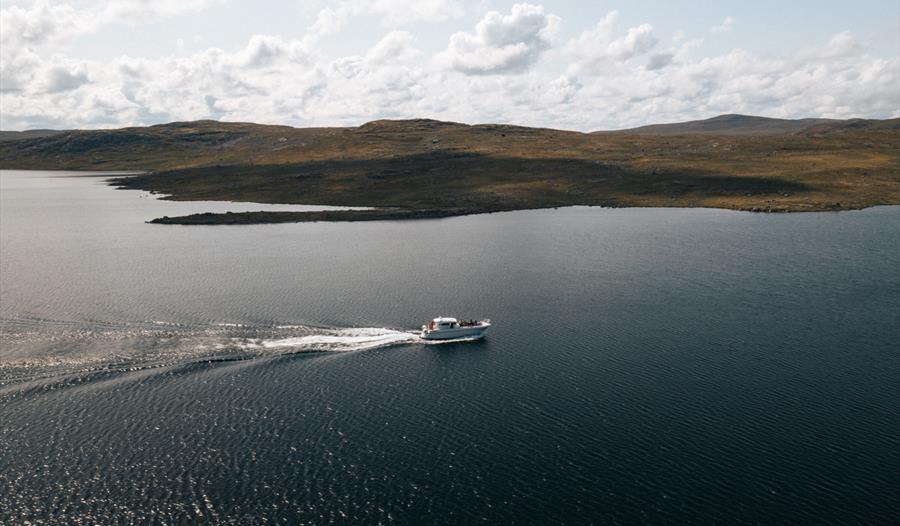 Et dronebilde av båten «Halnekongen» midt på Halnefjorden.