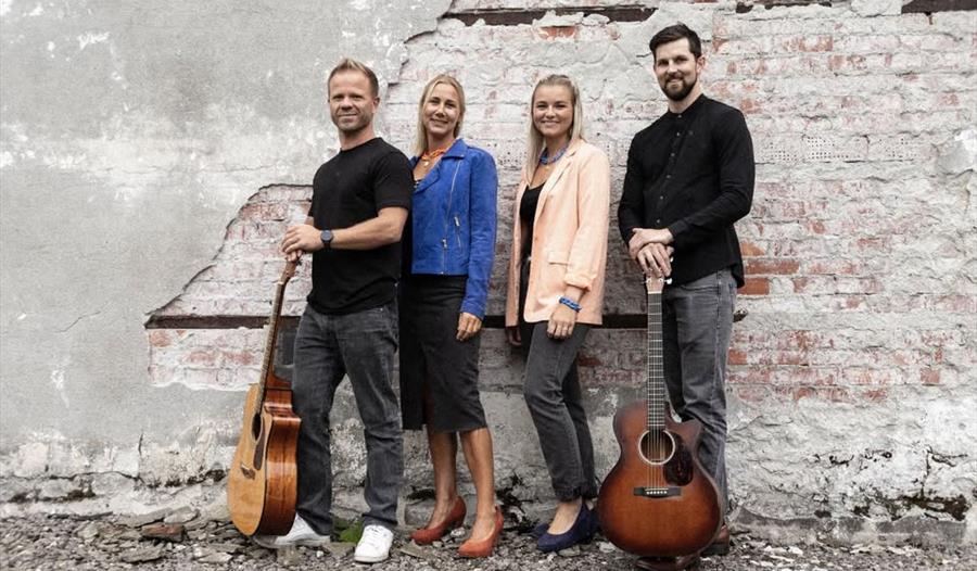 Bilde av et band bestående av to menn med gitarer og to kvinner.