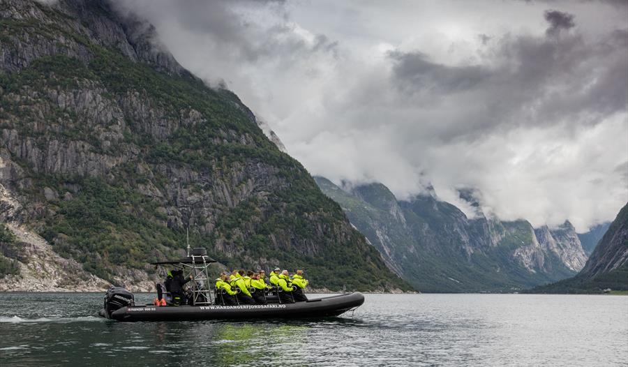 En ribbåt på fjorden, fylt med passasjerer.