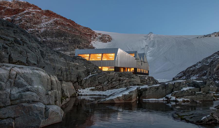Moderne arkitektur ved Fonna1199 med isbreen Folgefonna i bakgrunnen, midt i Hardanger sitt majestetiske landskap.