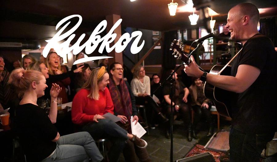 Musiker Nils Christian Fossdal spiller gitar og ler.