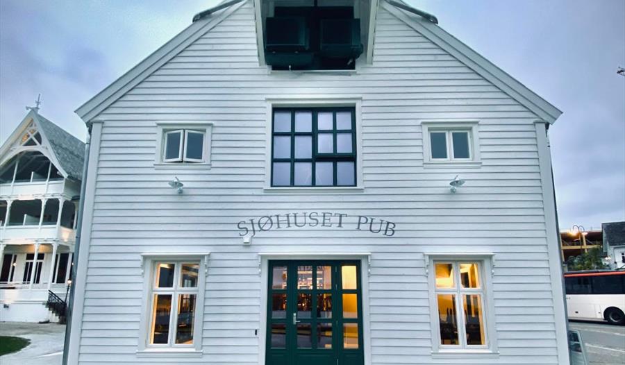 Sjøhuset Restaurant & Pub i Norheimsund - en koselig restaurant ved vannkanten med store vinduer som vender ut mot Hardangerfjorden. Moderne nordisk interiørdesign med naturlige treelementer og stemningsfull belysning.