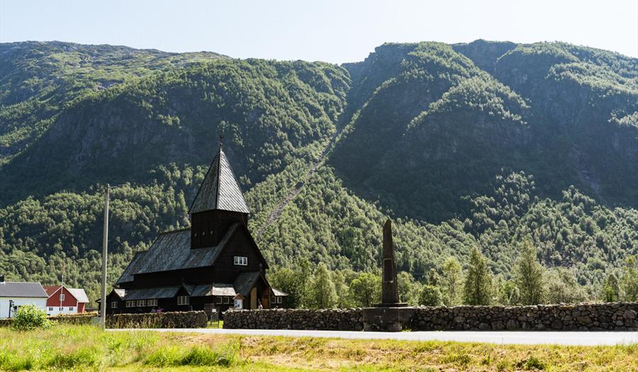 Røldal Stavkyrkje skin om kapp med sola på sommarstid.