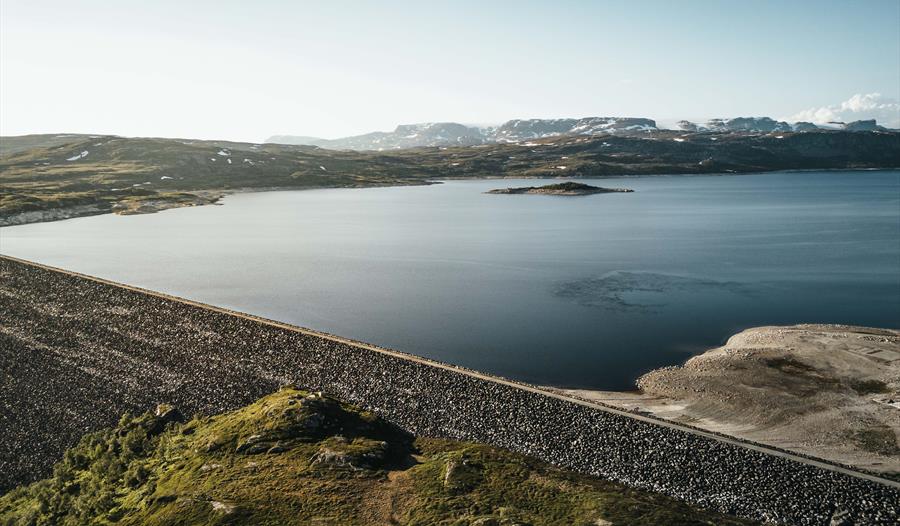 Et dronebilde av Sysendammen-demningen under solnedgang.