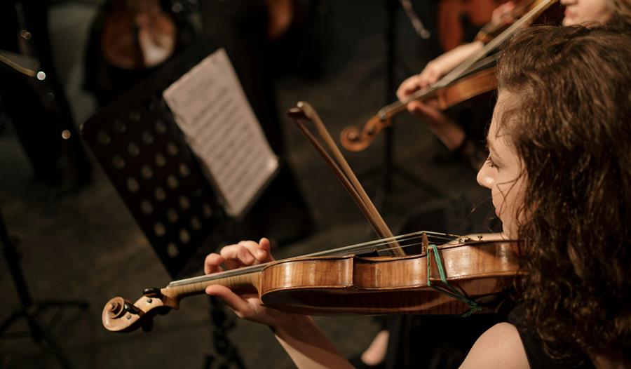 Brunette Woman Playing on Violin in Orchestra