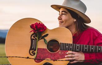 Margo Cilker med gitar dekorert med stor rød blomst