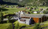 Et dronebilde av Norsk Natursenter med hus og gårder i bakgrunnen.
