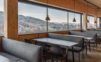 Restaurant på Fonna1199 med store vindauge og utsikt mot Hardangers dramatiske fjellformasjonar