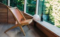 Komfortabelt sitteområde i Woodnest tretopphytte med store vindauge og utsikt til naturen utanfor.