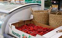 Saftige bringebær i ei kasse merka “Norske Bær”, klare for sal i den sjarmerande gardsbutikken i Øystese.