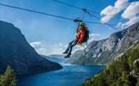 Deltakar på Trolltunga Zipline svevar høgt over fjord og bratte fjell i Hardanger.