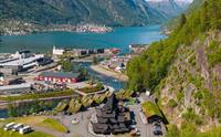 Oversikt over Odda med Valhall-anlegget nedst, Sørfjorden og snødekte fjell i bakgrunnen.