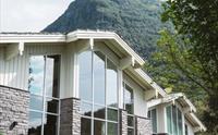 Fasaden til Rosendal Fjordhotel med fjellandskap i bakgrunnen