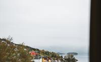 Utsikt frå rom på Rosendal Fjordhotel mot hardangerfjorden og sjarmerande hus