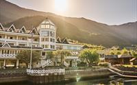 Hotel Ullensvang med hage og fjordutsikt i gyllen kveldssol – ein klassikar i Hardanger.