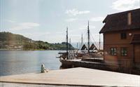 Roleg stemning ved Hardanger Fartøyvernsenter, med utsikt mot fjorden og historiske fartøy ved brygga.