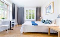 Elegant hotellrom med store vindauge, mykje naturleg lys og naturskjønn utsikt over Hardanger.